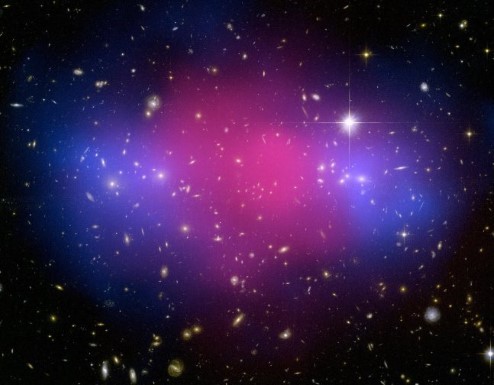 A photograph of the Bullet Cluster, showing a central mass of gas surrounded on either side by two lumps of dark matter.